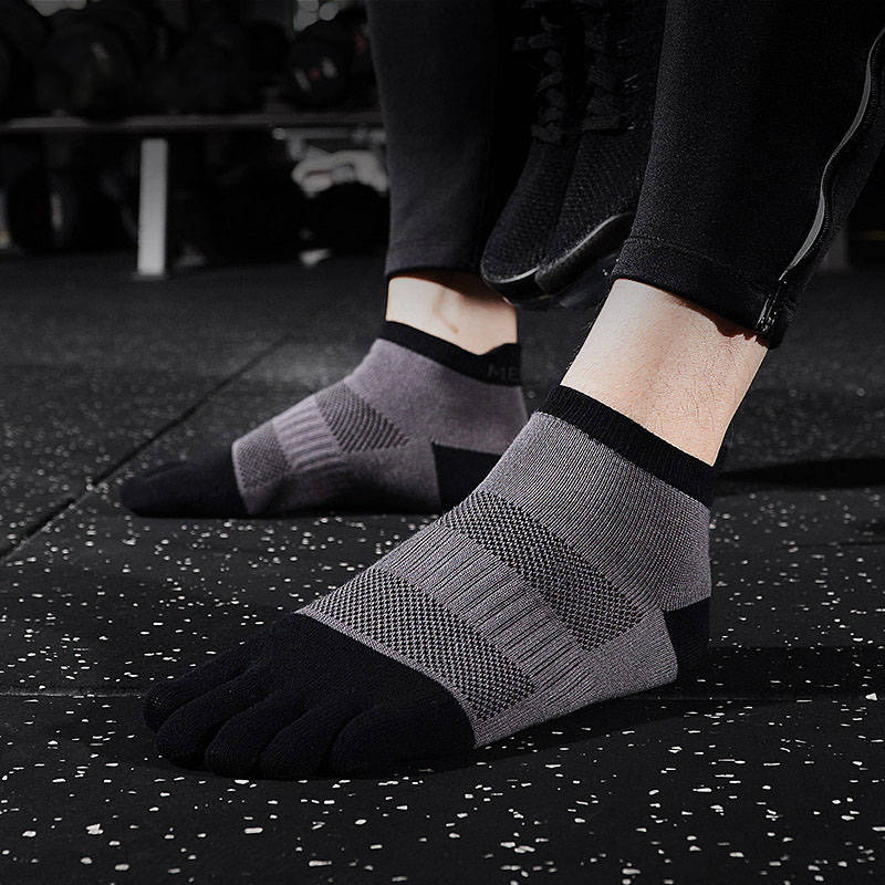 Person wearing black and gray toe socks with a supportive design in a gym.