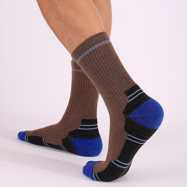 Brown and blue merino wool thick padded crew socks worn during hiking with durable comfortable fit